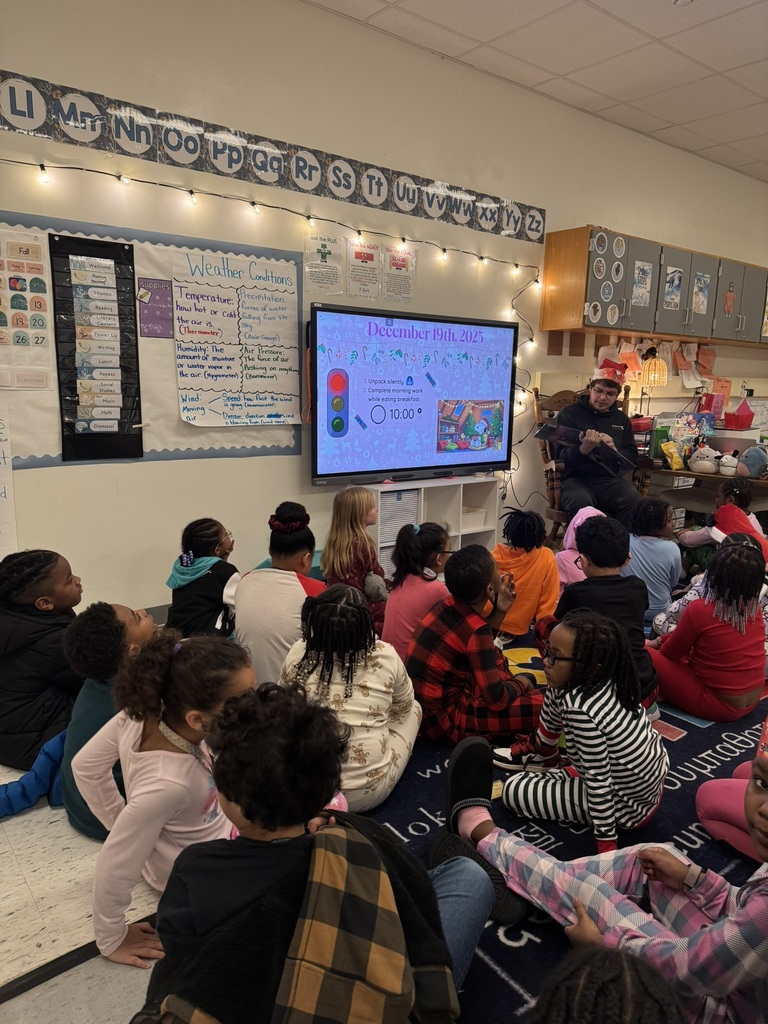 Ms. Roselle and Ms. Kay's class enjoy a story from a Mystery Reader
