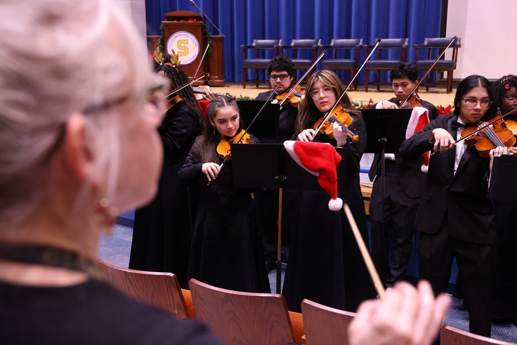 Orchestra students playing music.