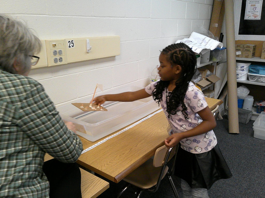 A student places her boat in the testing "lake"
