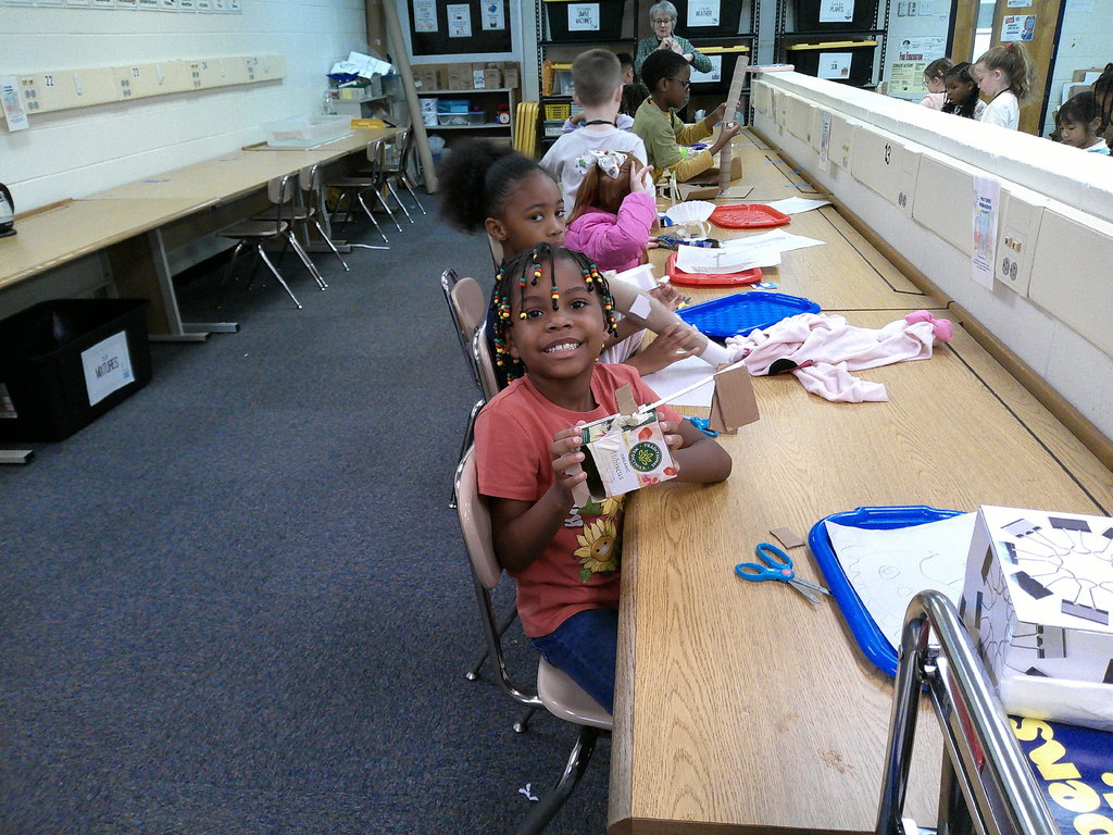 One student poses with her boat design