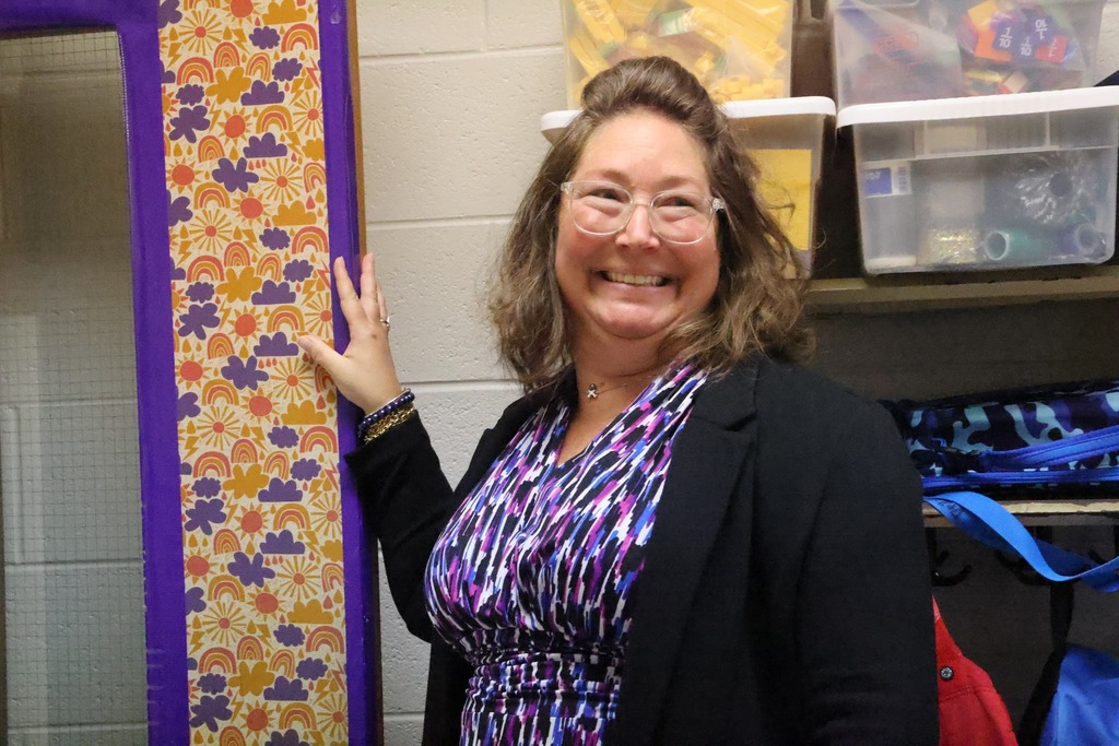 female prnicipal smiling at door