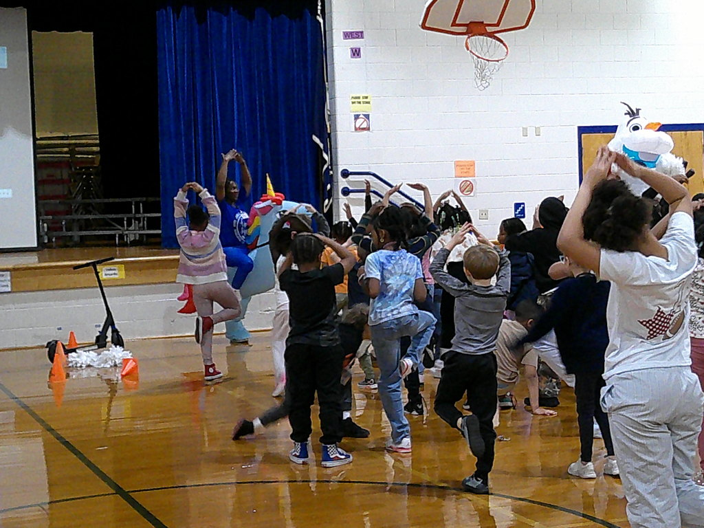 Mrs. Foard and students do the flamingo pose