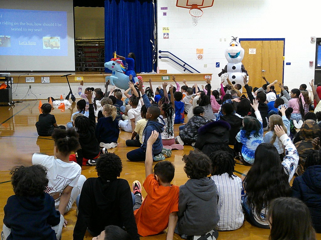 students participating at PBIS Pep Rally - hands raised to answer the question and spin the wheel