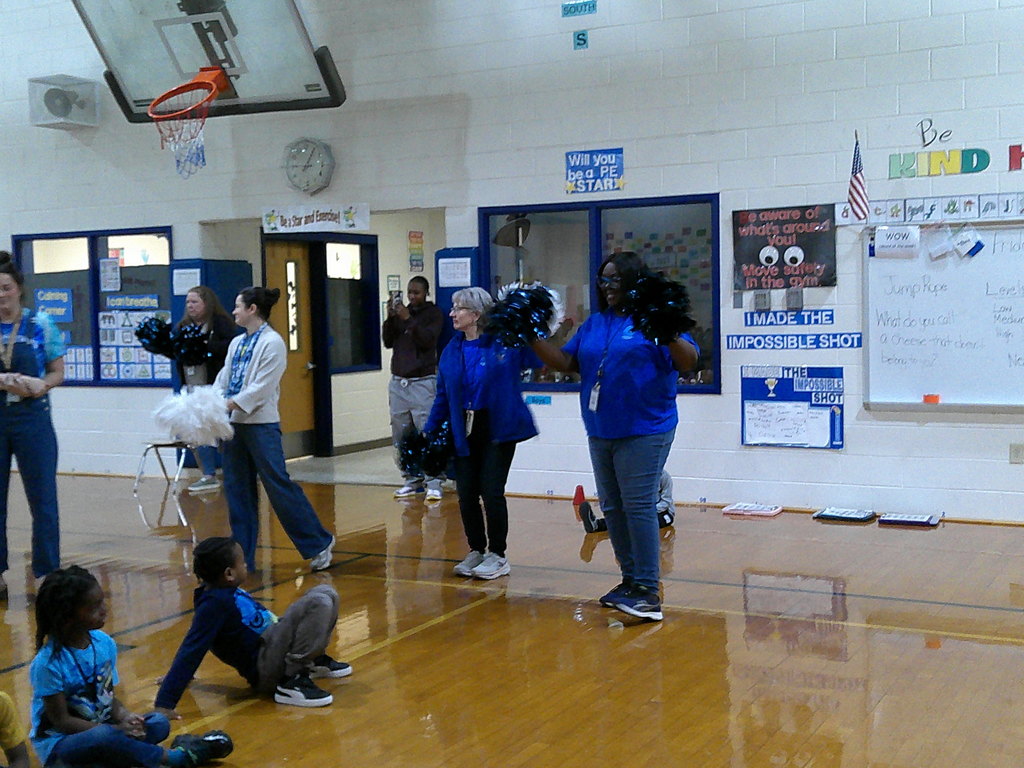 first grade teachers show their school spirit with pom poms