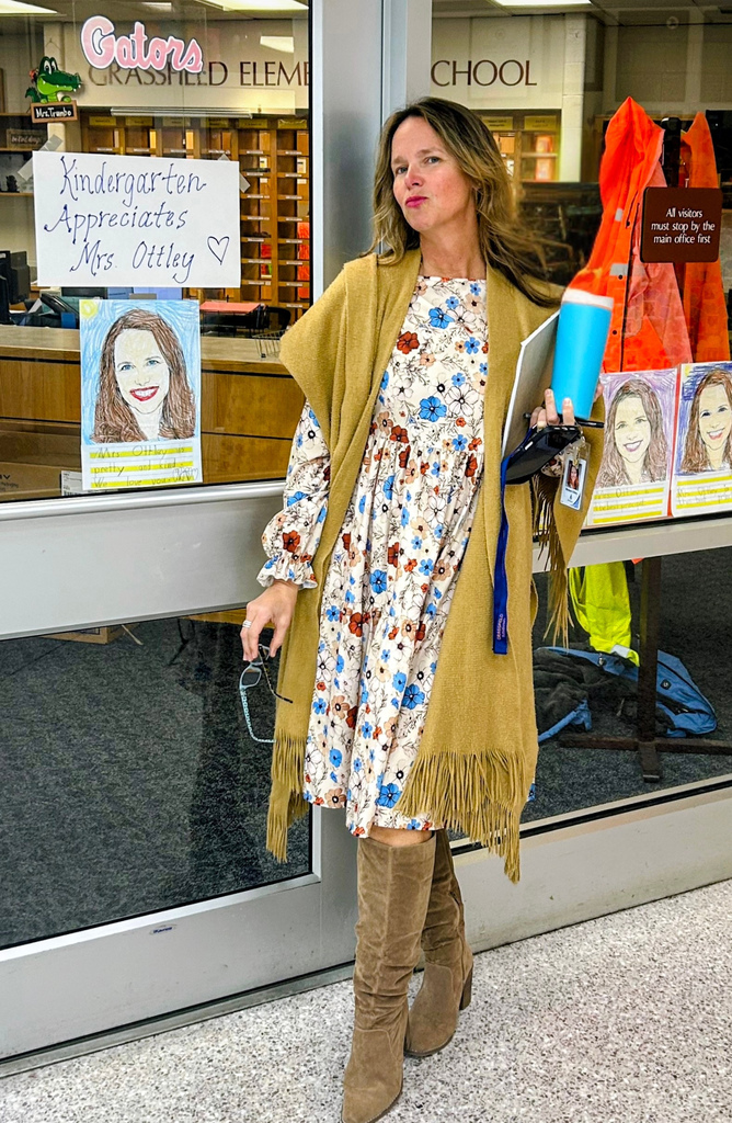 Mrs. Ottley surrounded by creativity and love—kindergarten students proudly displaying the portraits they created of her in appreciation during Principal Appreciation Week.