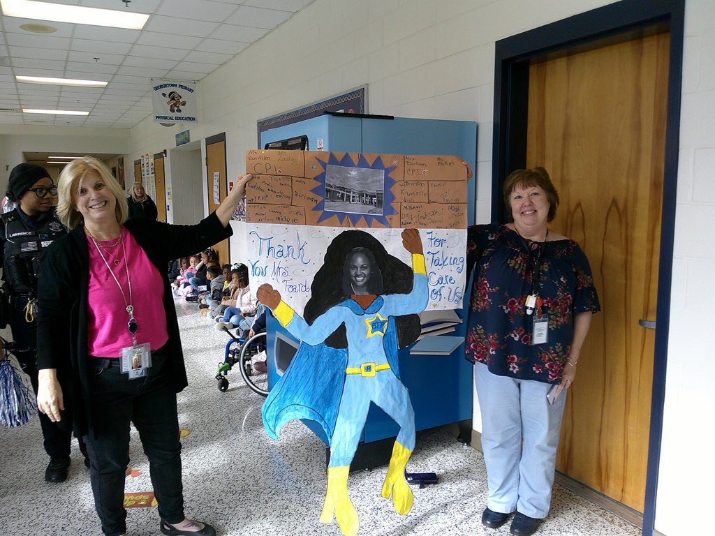 CPI teachers posing with their appreciation poster showing Mrs. Foard as a super hero