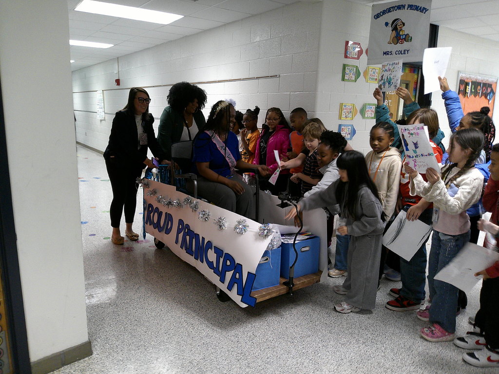 Mrs. Foard accepts gifts from third grade students in her parade float