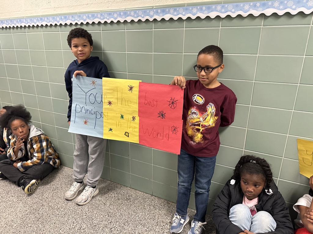 students with signs to celebrate the principal Mrs. robinson