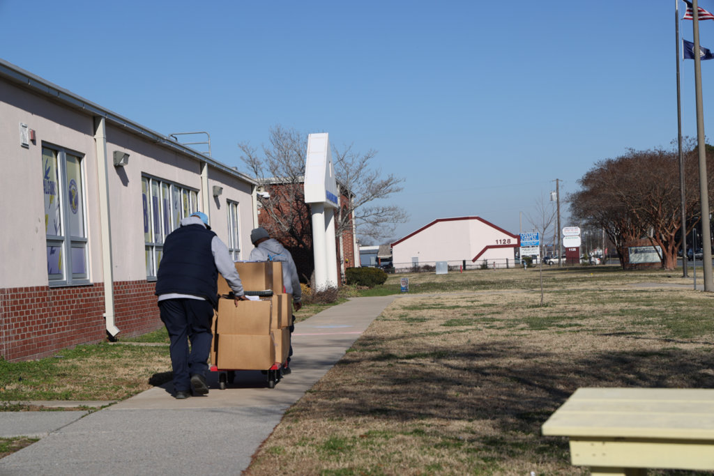 Ron and emanuel rolling cart of boxes into school