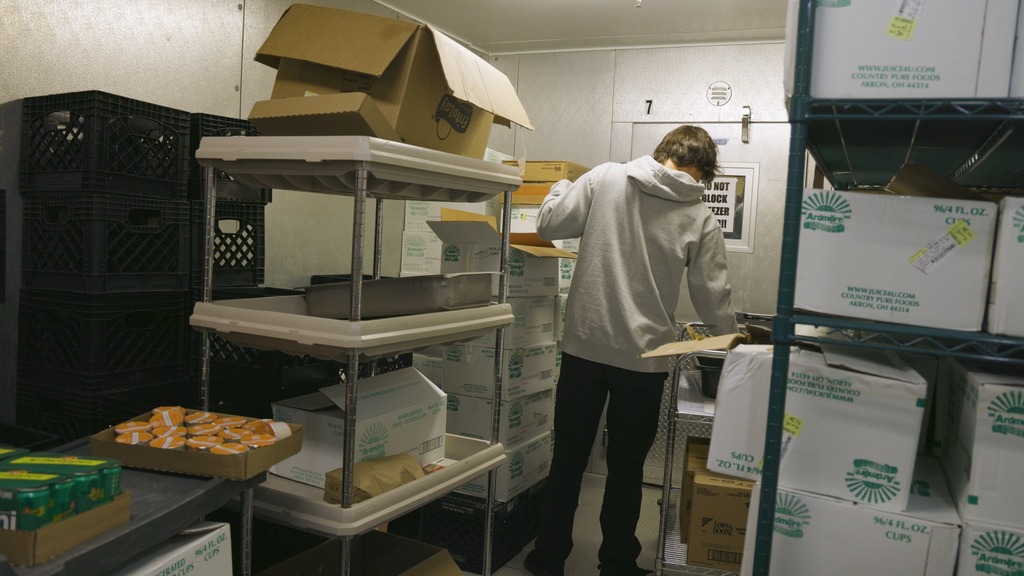young man unloading freezer items in a walk in freezer
