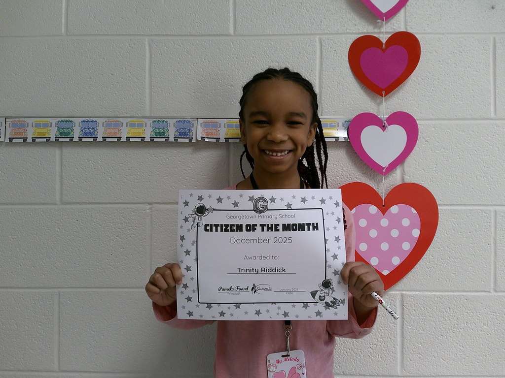Trinity Riddick holding her Citizen of the Month certificate
