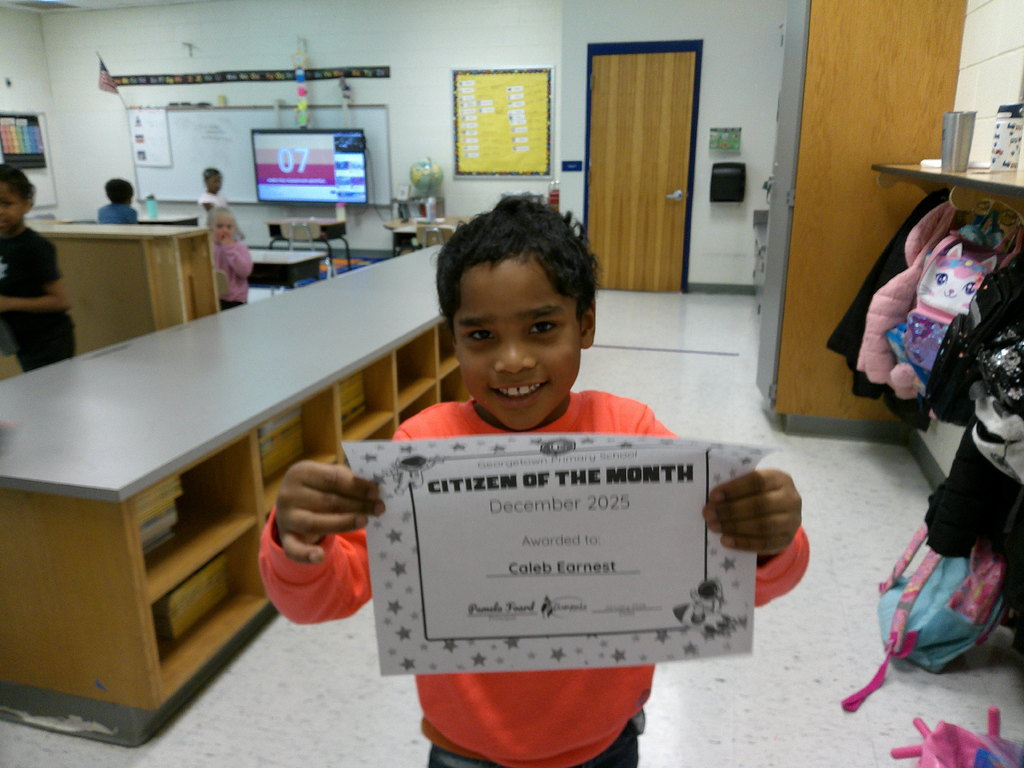 Caleb Earnest holding his Citizen of the Month certificate