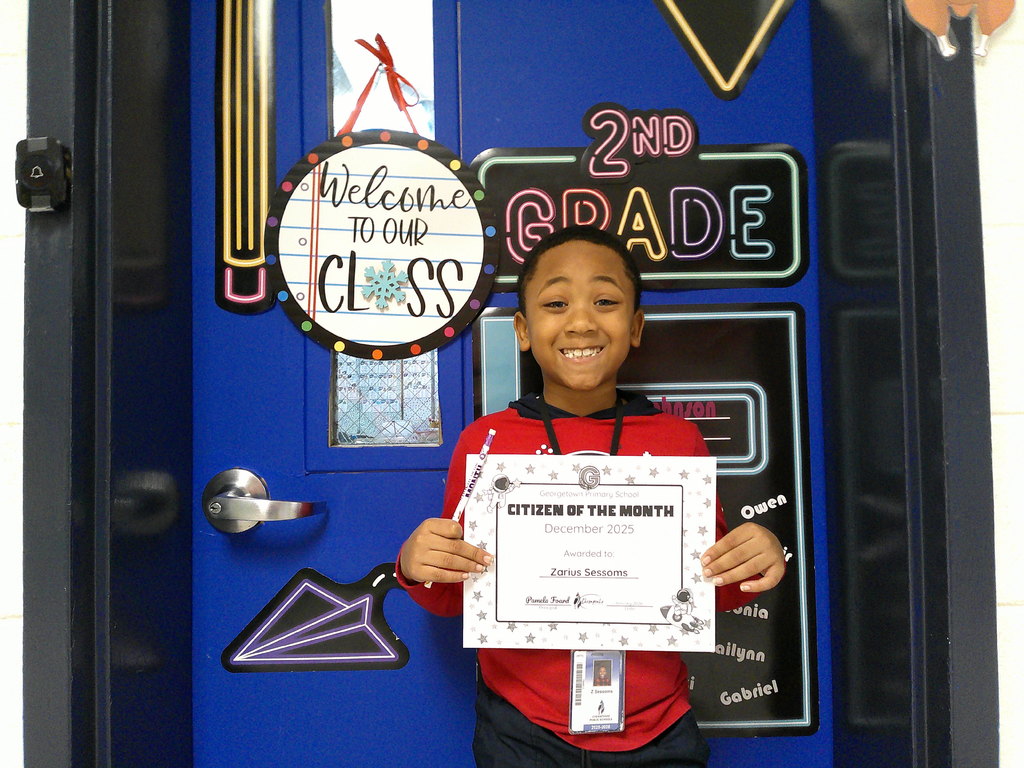 Zarius Sessoms holding his Citizen of the Month certificate