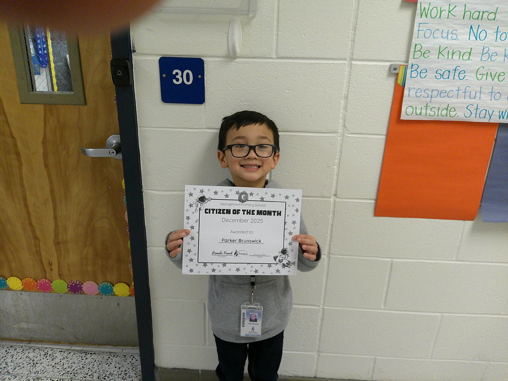 Parker Brunswick holding his Citizen of the Month certificate