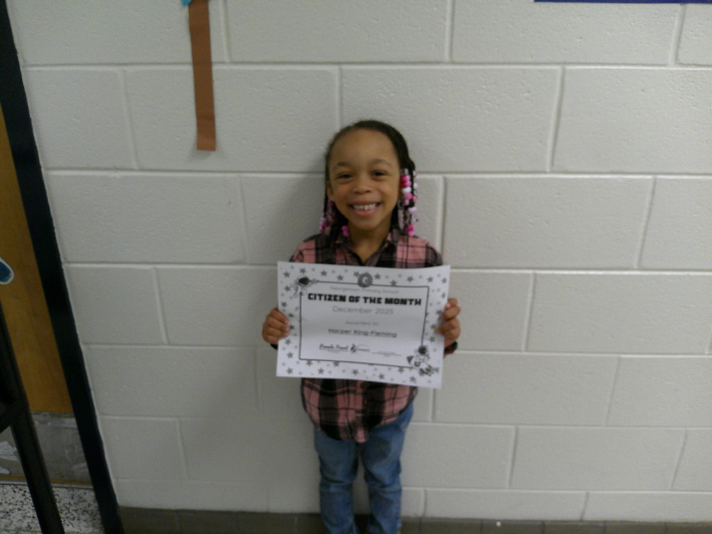 Harper King-Fleming holding her Citizen of the Month certificate