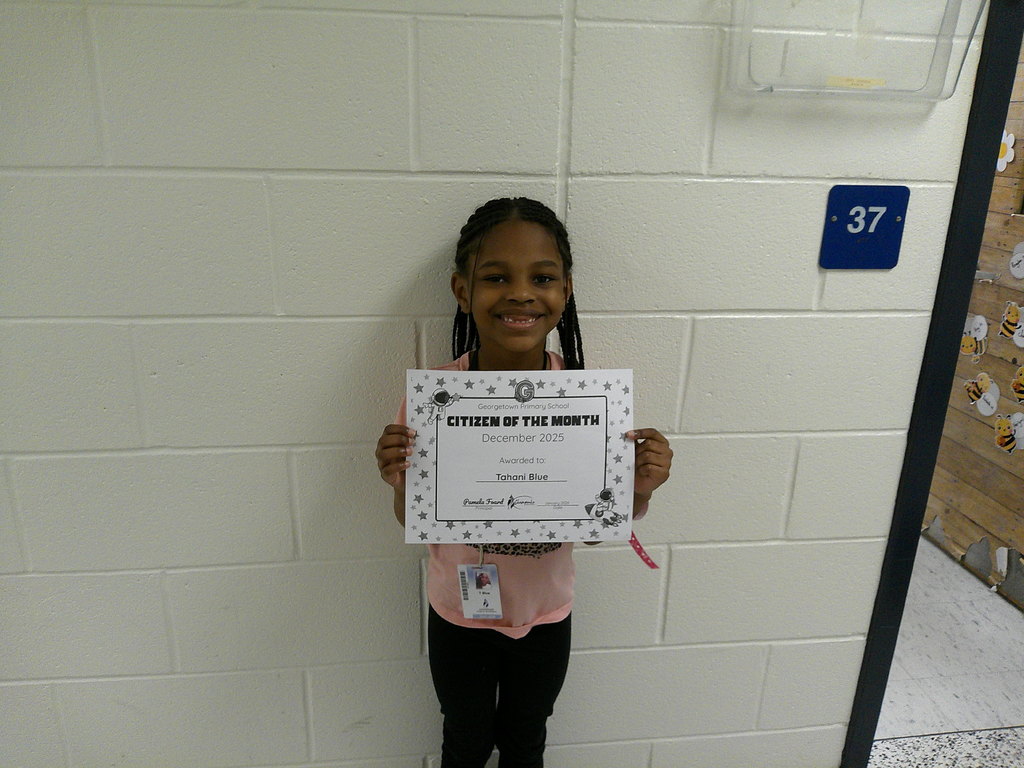 Tahani Blue holding her Citizen of the Month certificate
