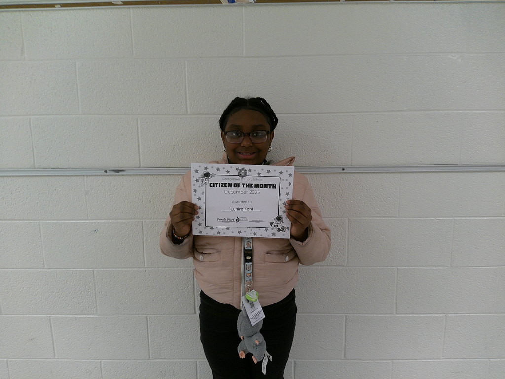 Cynira Ford holding her Citizen of the Month certificate