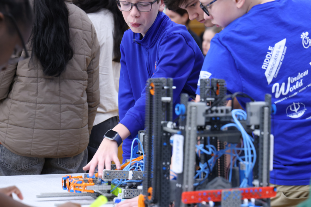 three boys discussing robot