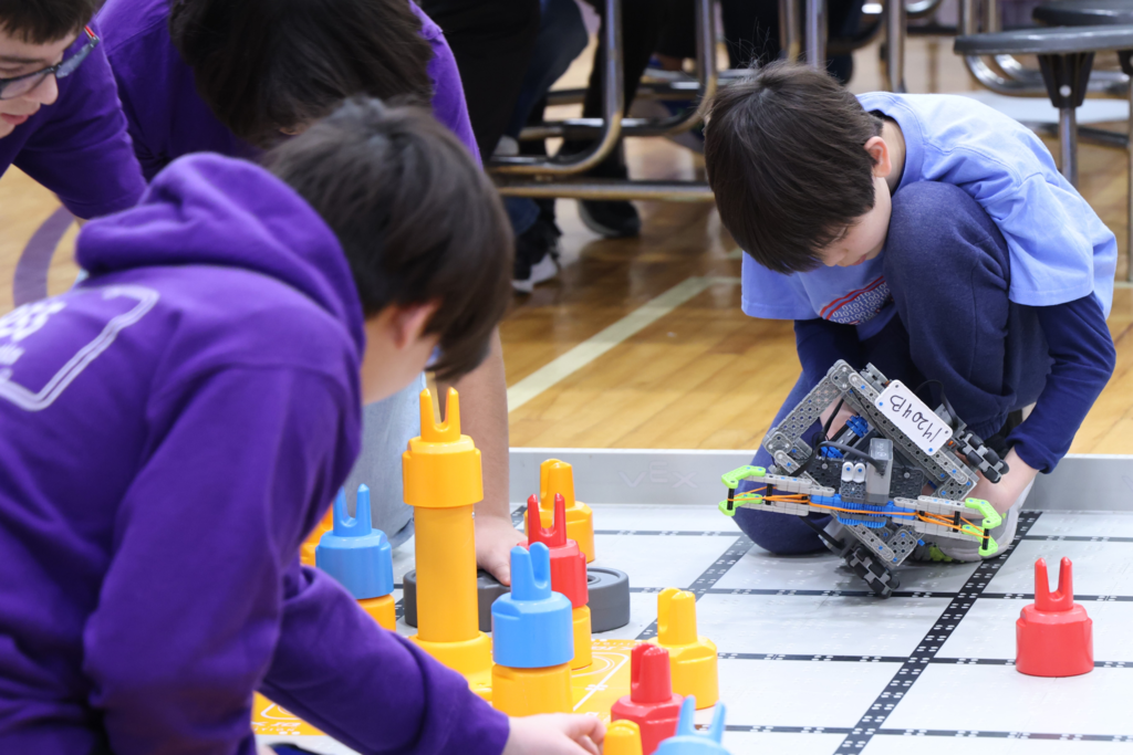 Middle school boy playing with robot