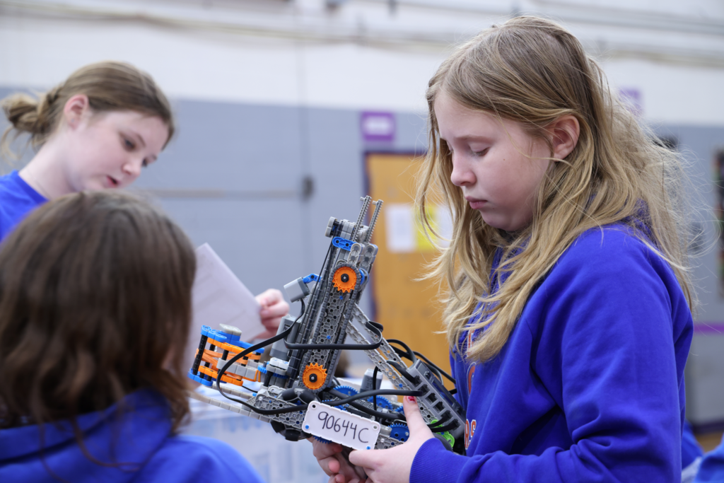Profile of middle school girl holding robot