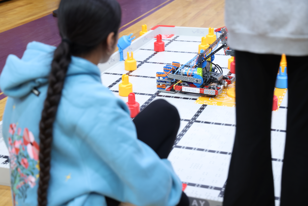 girl from behind on floor controlling robot