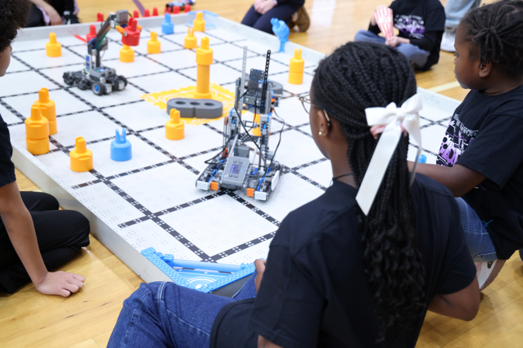 Image of girl from behind controlling a robot