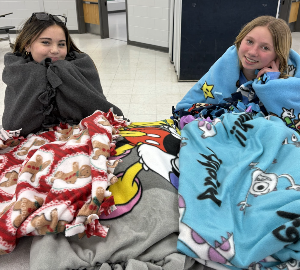 students holding up blankets