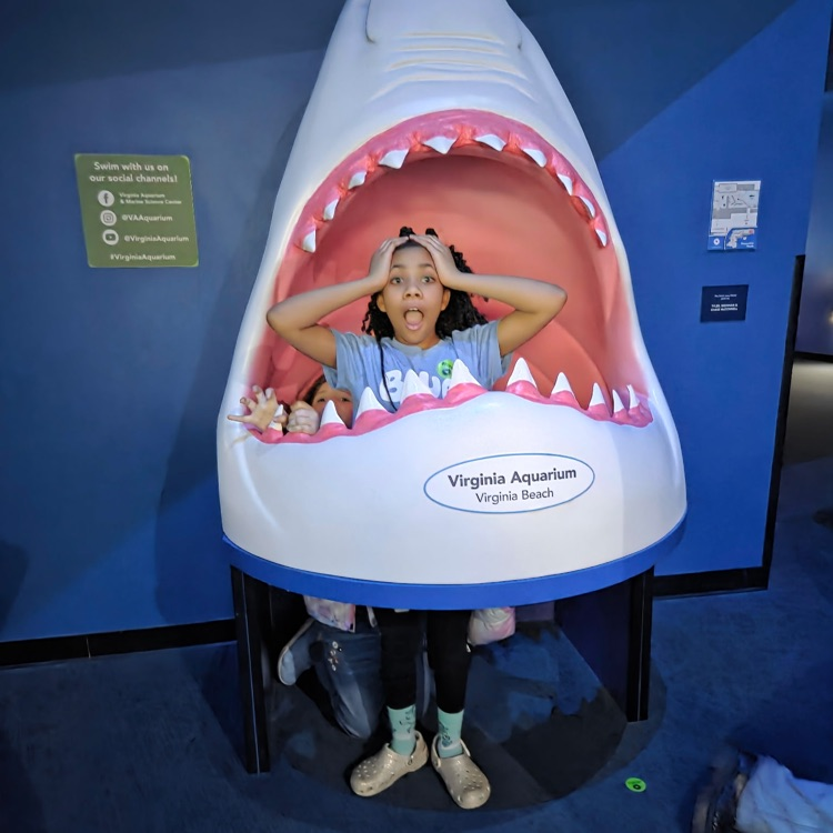 student in shark statue