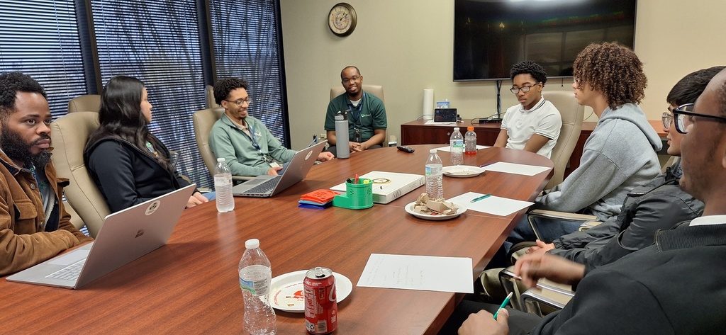group of students and mentors around conference table. 