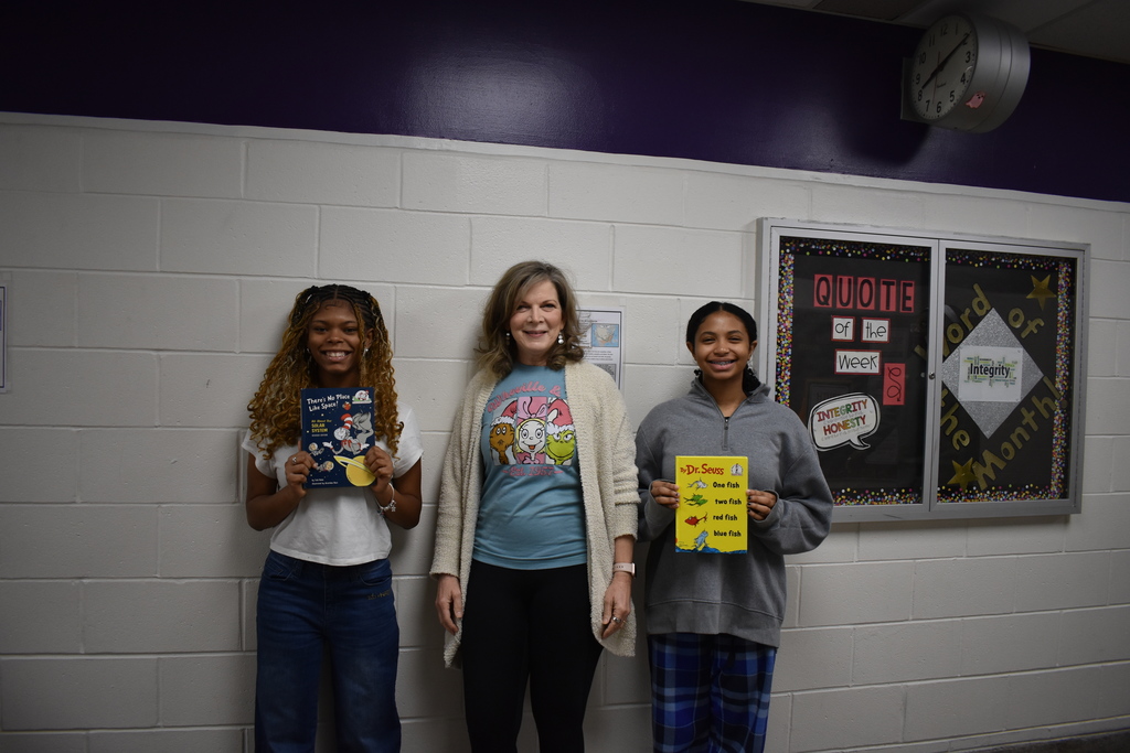 A teacher and two students with their Dr. Seuss books.