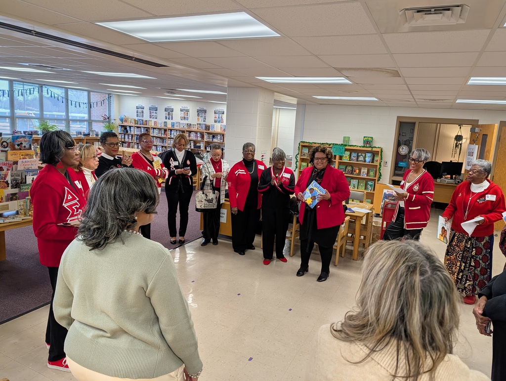 ladies wearing a red standing in a circle in a library