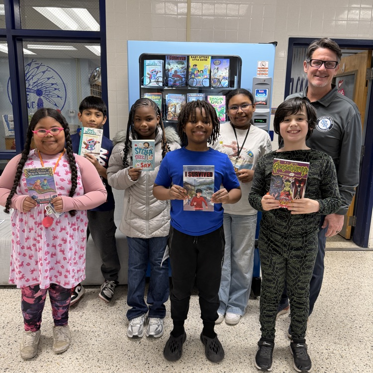 students for kindness in front of book machine with Mr. Triolet. 