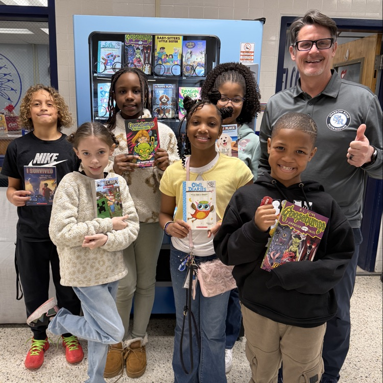 students for kindness in front of book machine with Mr. Triolet. 