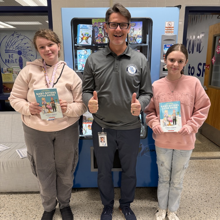 students for kindness in front of book machine with Mr. Triolet. 