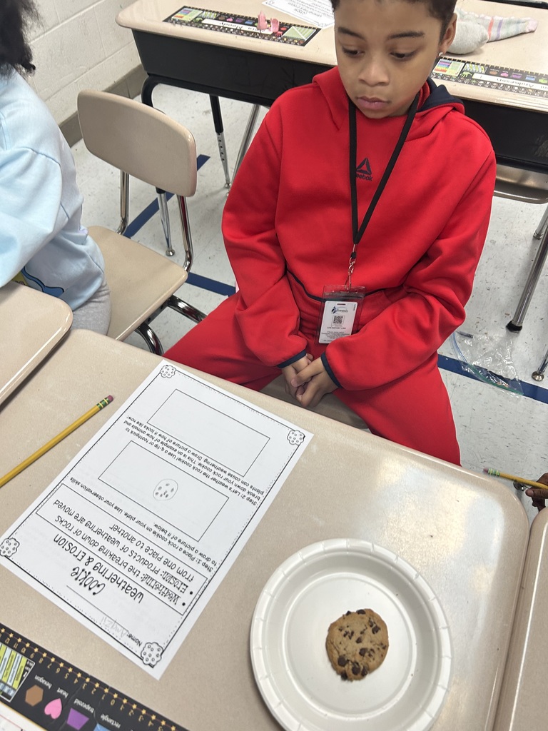 A student sitting with his cookie sitting on the desk for the erosion experiment