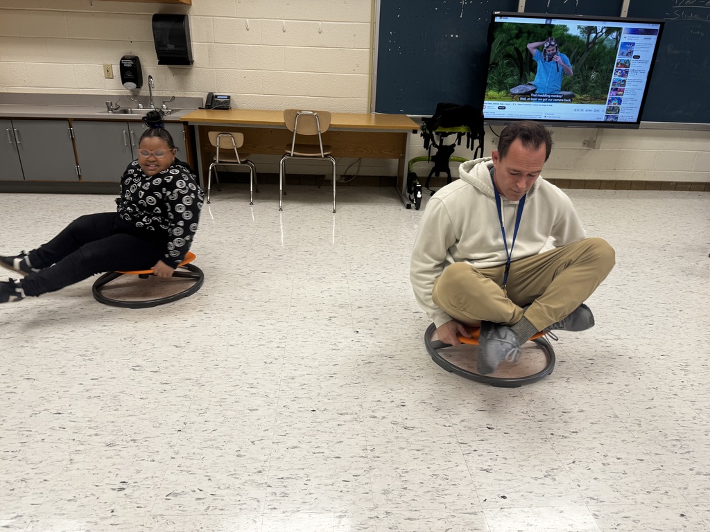 Georgetown Primary teacher Mr. Pippin spinning with a student during adaptive PE.
