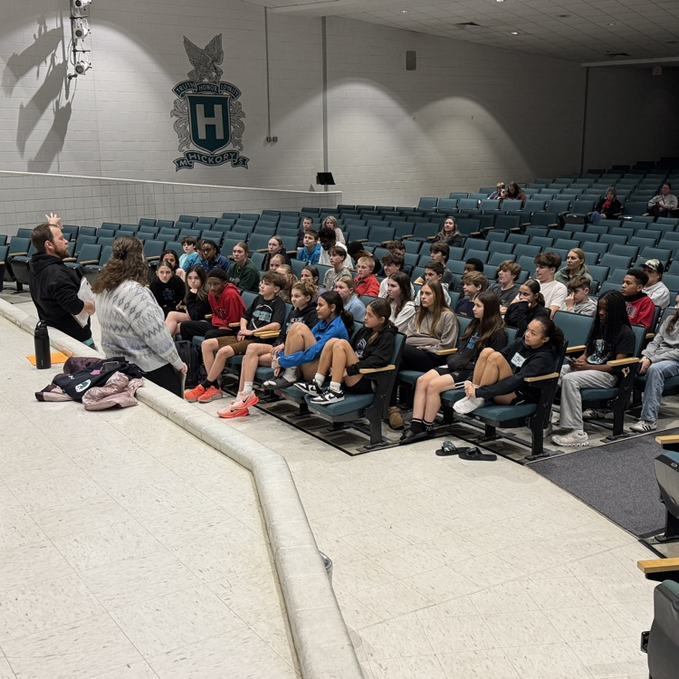 students and parents in team meeting with coach