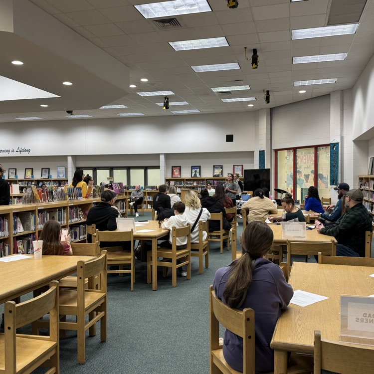 students and parents in team meeting with coach