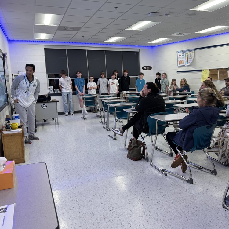 students and parents in team meeting with coach