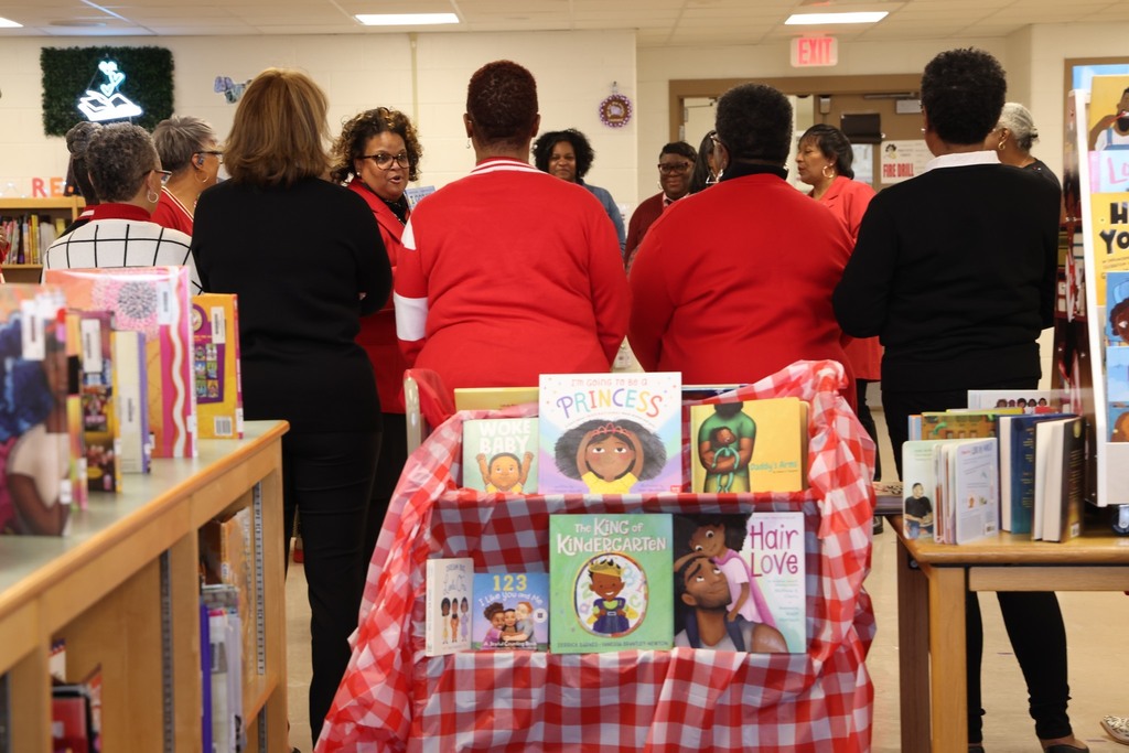 books on shelves with sorority sisters standing ina circle behind