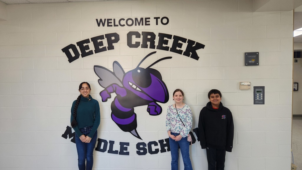 Our three contest winners standing in front of our Welcome to deep Creek Middle School Hornet Sign