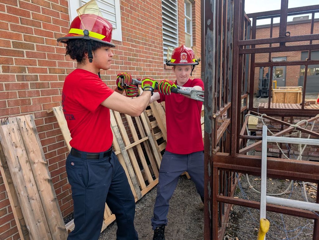 Firefighting students practicing forcible entry