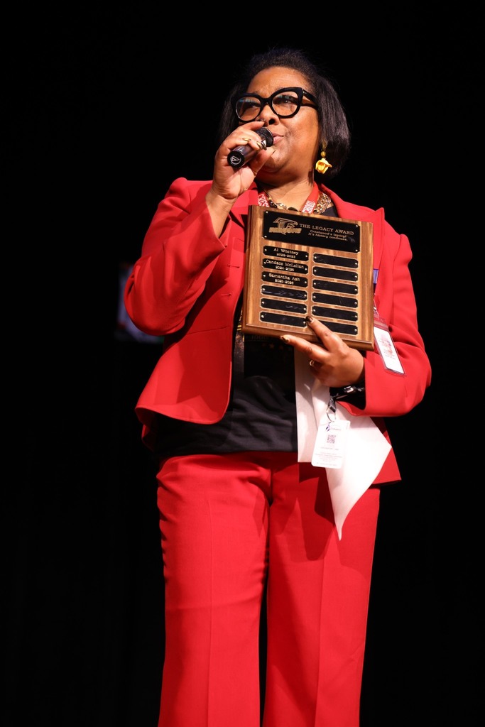 Crestwood Middle principal holding an award.