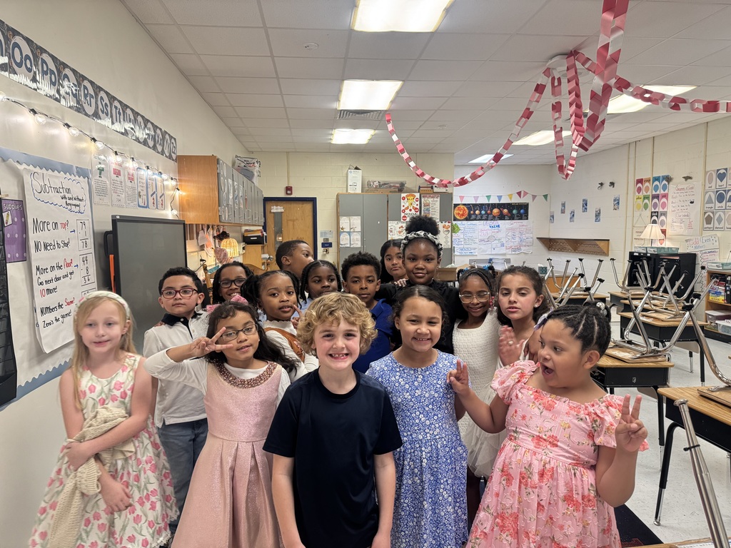 Ms. Roselle's students smiling in the classroom before going to their concert performance