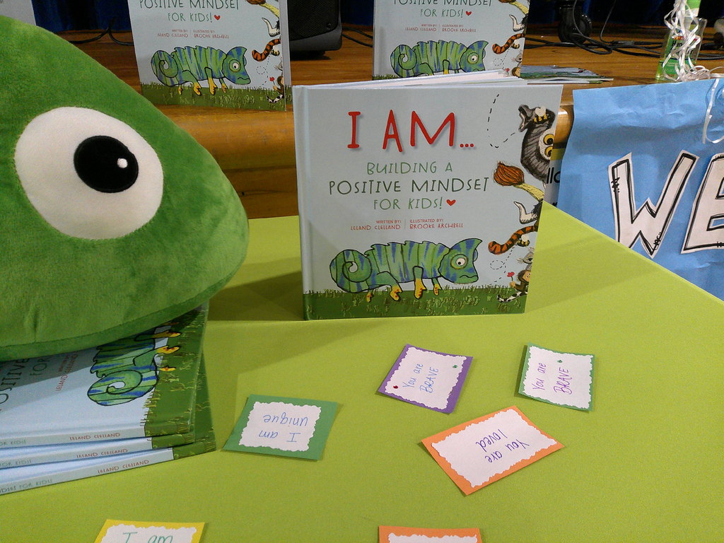 Leland Clelland's display table showing several copies of his book (I AM...Building a Positive Mindset) and affirmations from the story