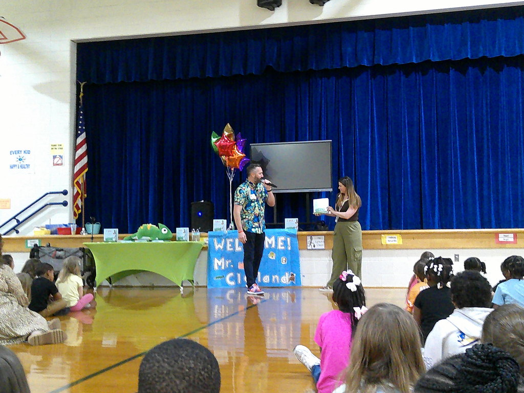 Leland Clelland reads his book (I AM...Building a Positive Mindset) to Georgetown Primary students while a teacher holds the book for him