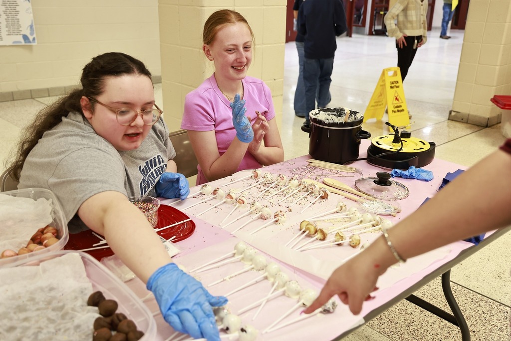 two girls at table with homemade cake pops