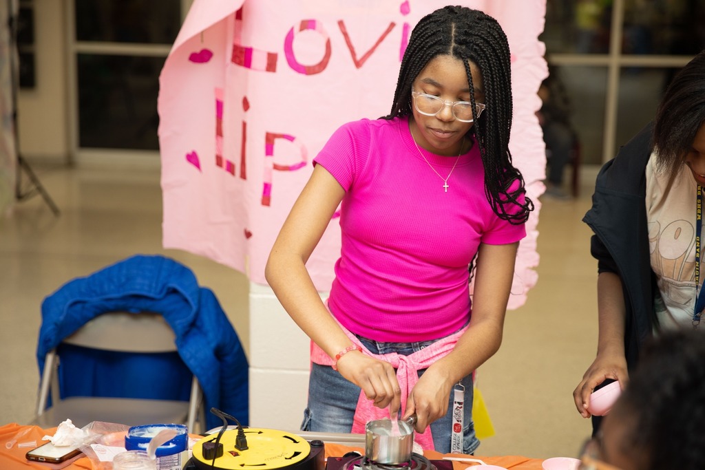 student stirring in measuring cup
