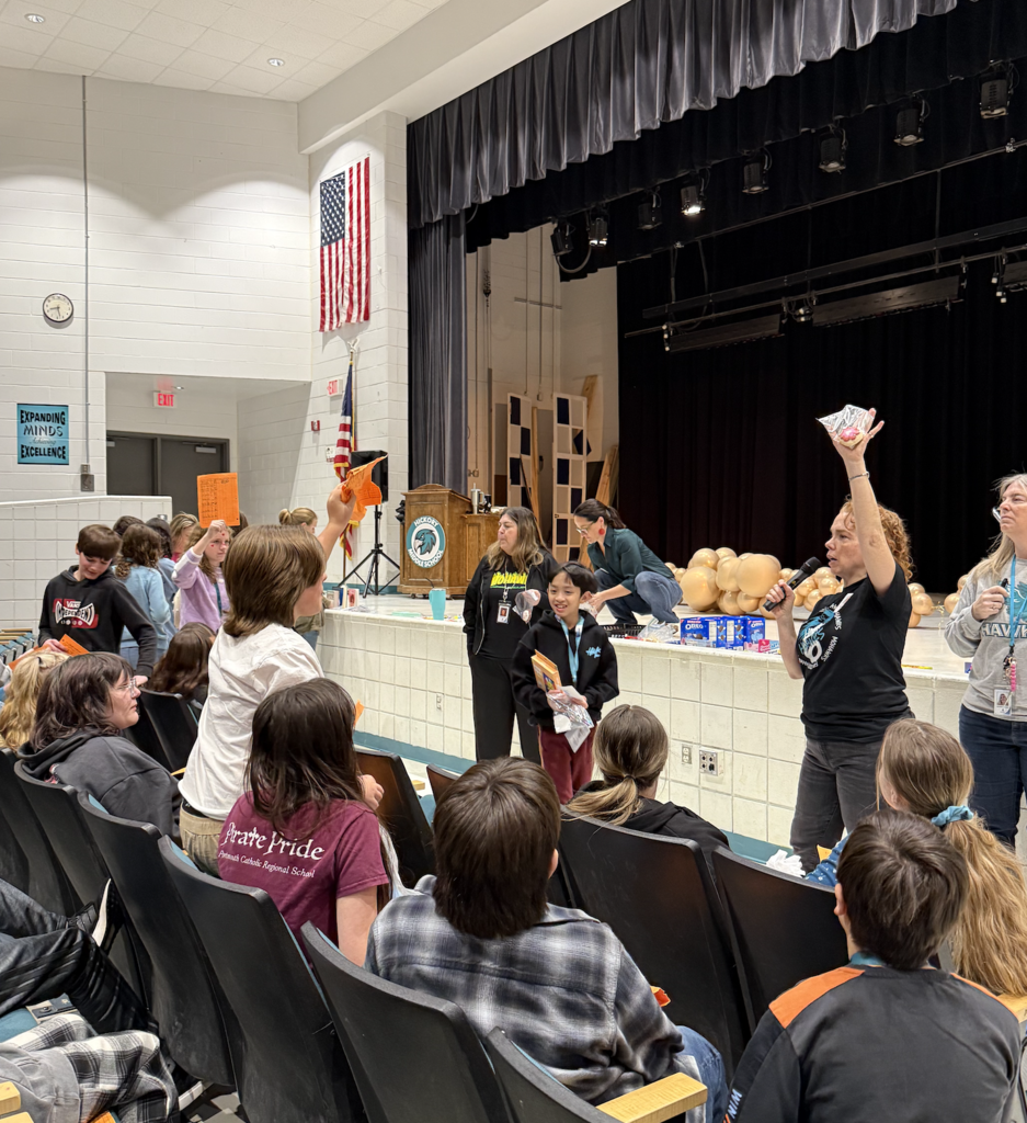 students in the auditorium for their team auction