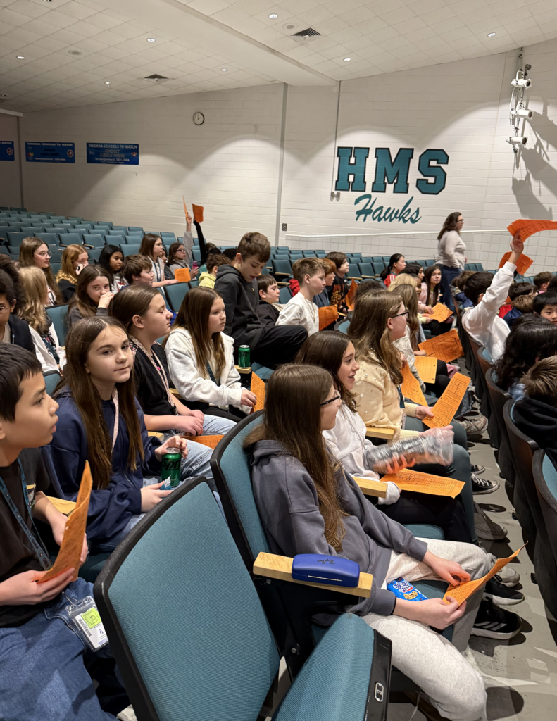 students in the auditorium for their team auction